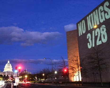 A projection reads 'No Kings 3/28' on an evening in Washington DC as the US Capitol can be seen in the background