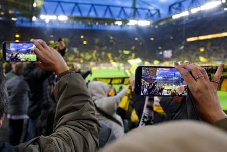An image of fans holding smartphones to take pictures of DortmundâÂÂs stadium before a match