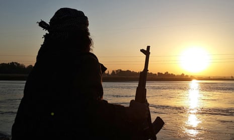 A Islamic State fighter looks over the Euphrates river in Raqqa, Syria. 