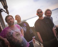 The four members of Chat Pile posing by a balustrade by the sea