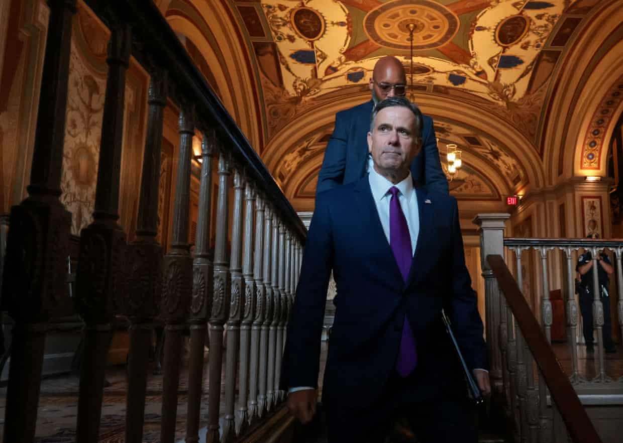 John Ratcliffe walks down a staircase in a government building on Capitol Hill