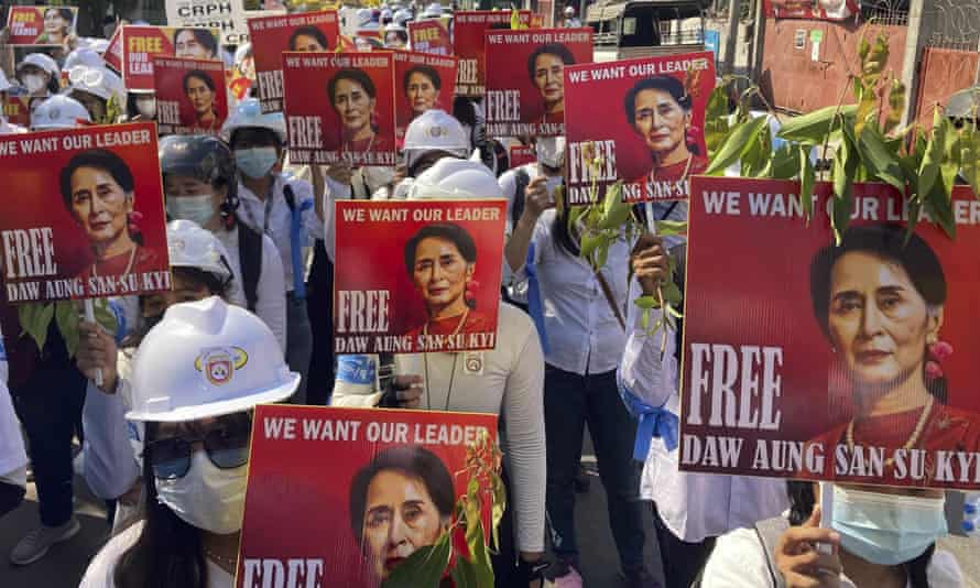 Protesters in Myanmar holding up portraits of Aung San Suu Kyi earlier this year.