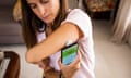 Woman monitoring the levels of glucose in her blood using a smartphone with sensor attached to her arm