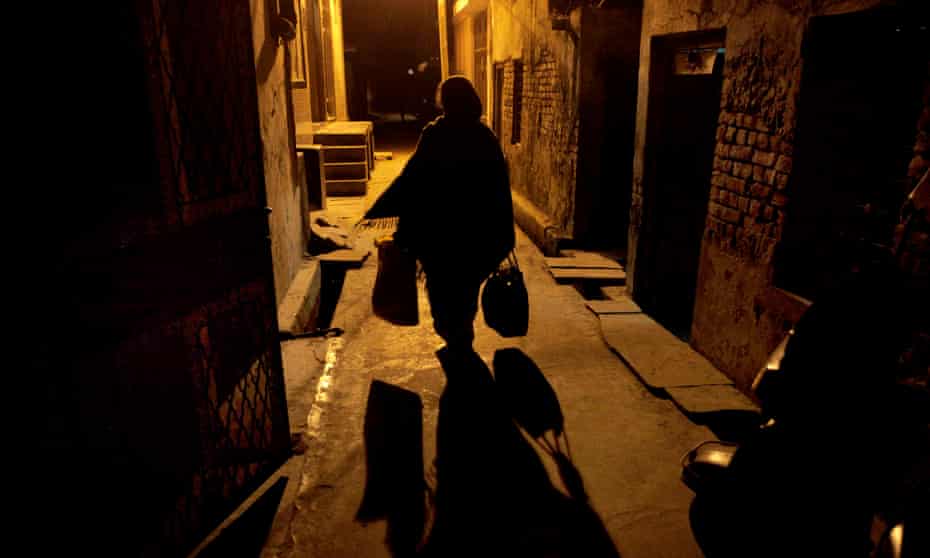 A woman returns home after a day’s work as a domestic help in New Delhi.