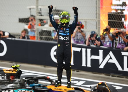Lando Norris celebrates on his car after becoming world champion