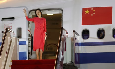 Meng Wanzhou waves at a cheering crowd as she steps out of a charter plane in Shenzhen