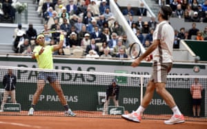 Roger Federer looks on as Rafael Nadal gets ready to smash a return back in his direction.