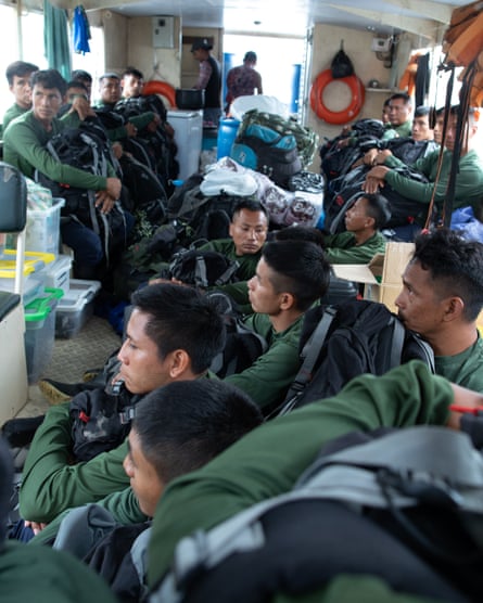 Young Indigenous men sit on a boat