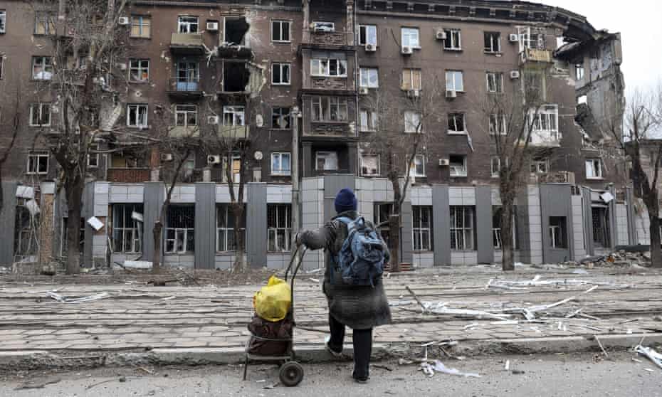 A Mariupol resident looks at a building near the Illich metallurgical plant damaged during heavy fighting between Ukrainian and Russian forces.