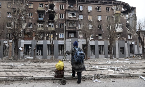 A Mariupol resident looks at a building near the Illich  metallurgical plant damaged during heavy fighting between Ukrainian and Russian forces. 