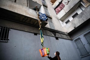 Marseille, France: a resident of a block of flats is passed food by his neighbours using a rope made of blankets