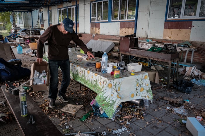 A local resident searches through leftovers outside a vacated retirement home in Martove, Kharkiv oblast.
