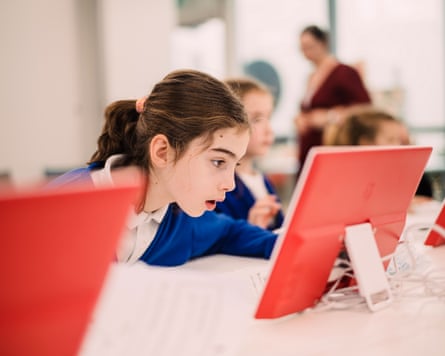 A girl looks at a computer screen in a classroom