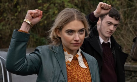 Imogen Poots and Lewis Brophy with their right hands in a raised fist salute.