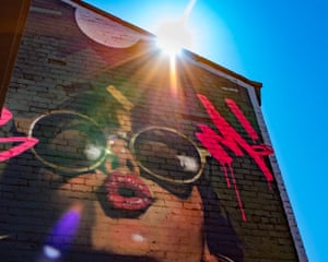 Glasgow, UK ‘Eastvale Place is an arts space and features regularly changing wall art on the surrounding buildings. As I was photographing this piece of a woman wearing sunglasses, I noticed that the sun, on a dazzlingly bright day, was directly overhead. Crouching down to a low angle, I was able to get the flare from the sun into the picture.’
