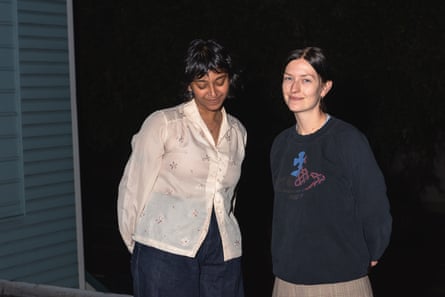 Two people pose for a photo outside in the dark