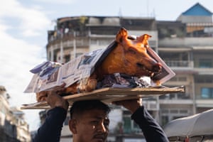 A person carries a roasted pig at a market ahead of Lunar New Year