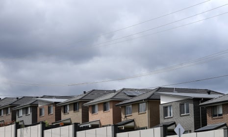 A row of identical houses against a cloudy grey sky