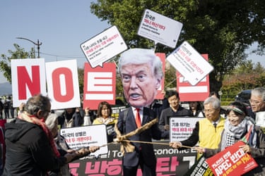 A small group of protesters, one of them wearing an oversize Trump mask