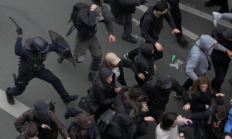 Riot police clash in France chase protesters with a baton