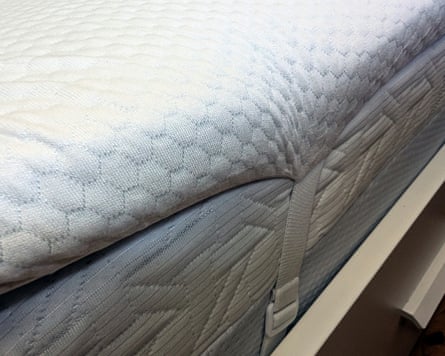 Closeup image of the side of the Panda Bamboo mattress topper attached by elasticated strap to a double mattress.