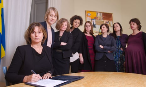 Flanked by colleagues, the Swedish deputy prime minister, Isabella Lövin, signs a bill.