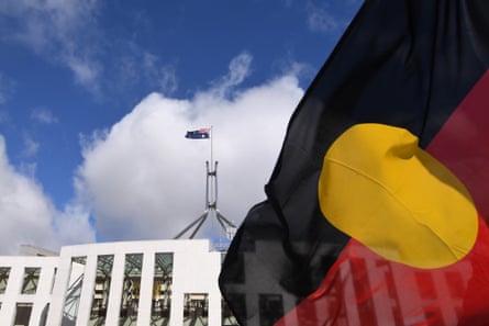 Australian Parliament House is seen through an Aboriginal flag in Canberra