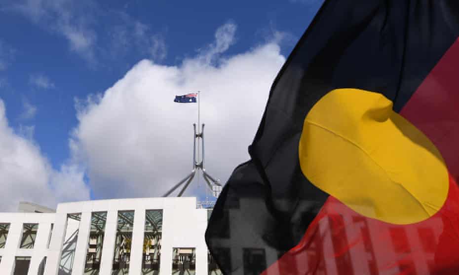 Australian Parliament House is seen through an Aboriginal flag in Canberra