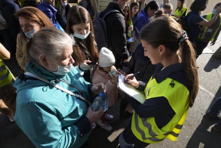Volunteers help Ukrainian refugees at the central train station in Warsaw, Poland, 23 March.