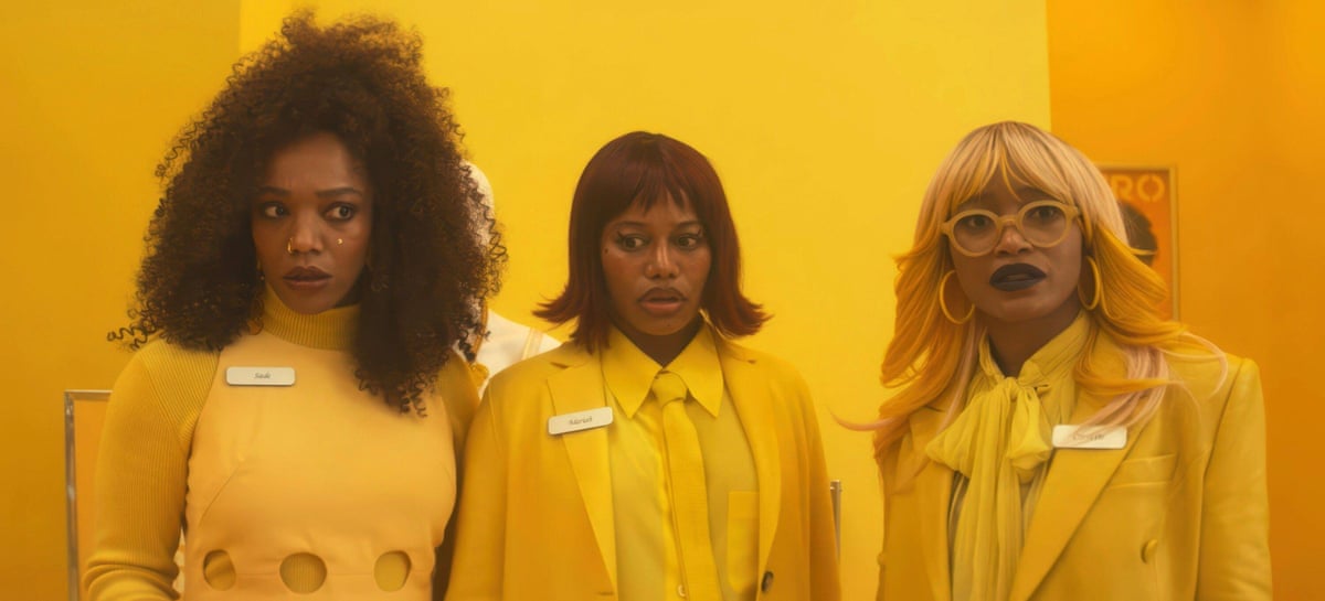 The three women all dressed in yellow stand merged into a yellow background