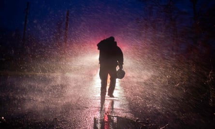 Montegut fire chief Toby Henry walks back to his fire truck in the rain in Bourg, Louisiana.