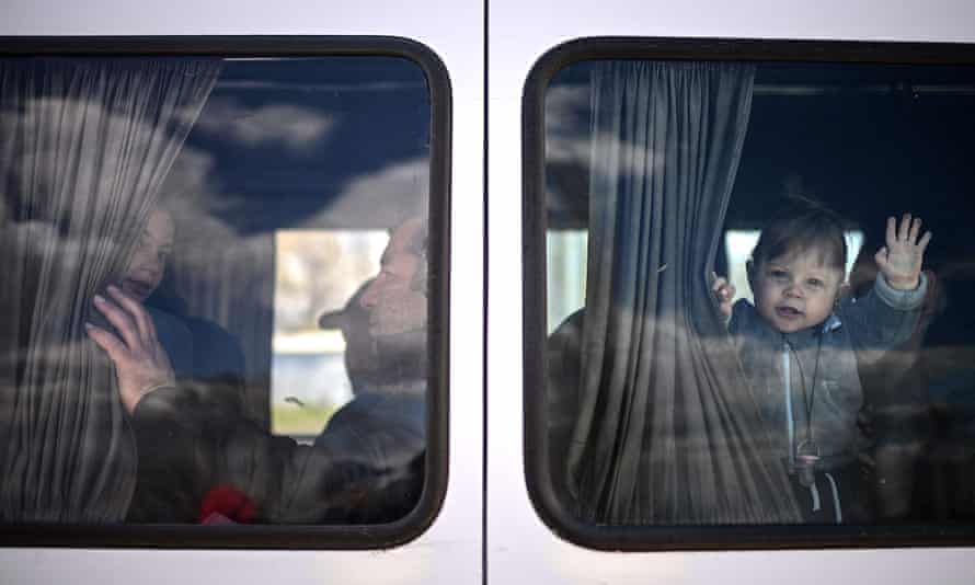 A young Ukrainian refugee waves from a minibus taking him and his mother further into Moldova after crossing the border in Palanca, south-eastern Moldova.