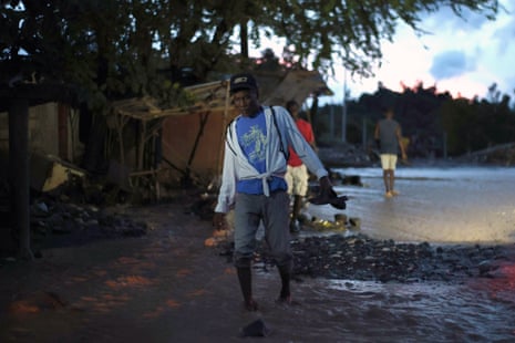 A person walks through mud left by flooding from the La Digue River in Petit-Goâve, Haiti.