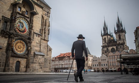 Man walking across near-deserted Old Town Square in Prague.