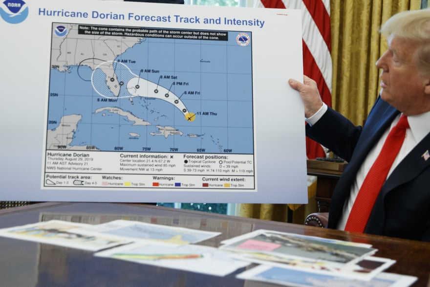 Donald Trump holds a chart in which the projected path of Hurricane Dorian appears to have been extended in makeshift fashion to include Alabama by means of a Sharpie pen.
