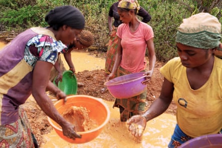 Women work at a washing station in Kailo to separate mineral ore from sand