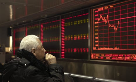 An investor monitors stock prices at a brokerage in Beijing on Tuesday, December 31.