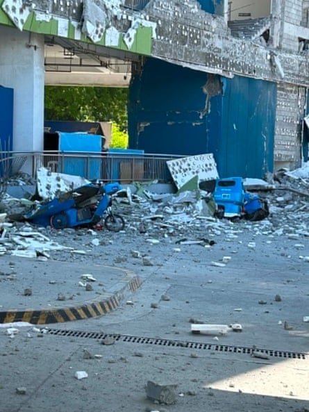 Vehicles damaged by debris after a powerful earthquake hit the Mindanao region in the Philippines on Monday.