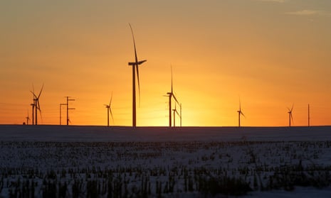 Wind turbines against a sunset.