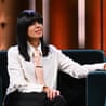 Claudia Winkleman on her chatshow sofa wearing a white blouse and peach tie