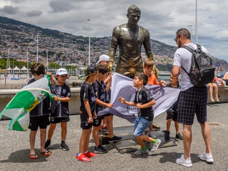Children pose in front of the Cristiano Ronaldo statue outside the CR7 hotel in Funchal, Madeira