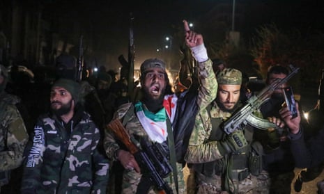 İslamcı öncülüğündeki Suriyeli muhalif savaşçılar, 8 Aralık 2024'ün erken saatlerinde Suriye'nin üçüncü büyük kenti Humus'a girdikten sonra sokaklarda kutlama yapıyor.