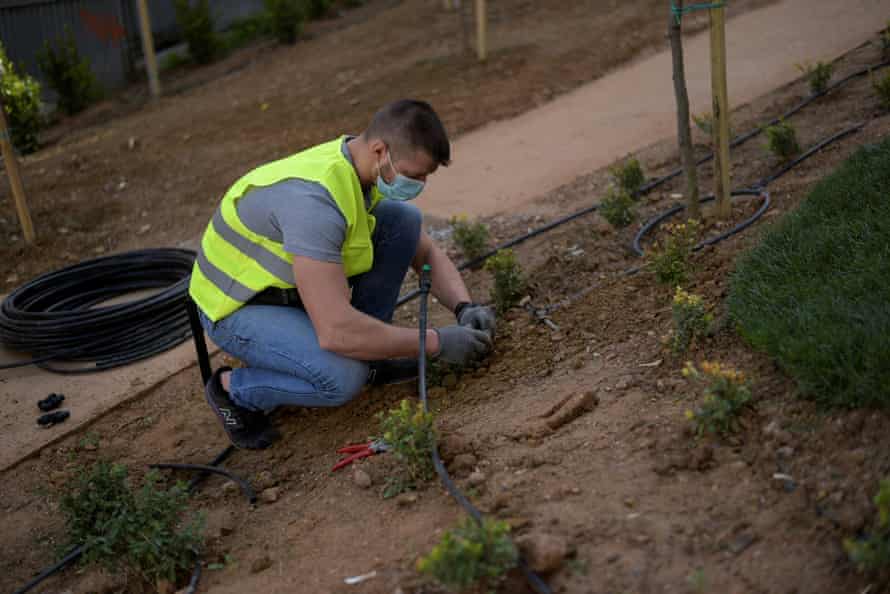 A municipal employee works at a pocket park in Athens, Greece.