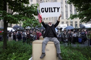 A demonstrator holds a placard reading “guilty” following the announcement of the verdict in former US president Donald Trump’s hush-money trial.