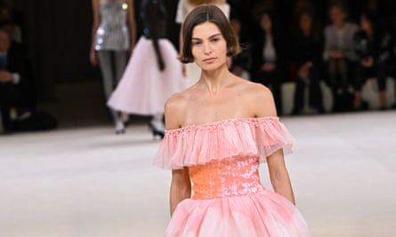 Midshot of model wearing pink dress with another model in tutu-style skirt in background.