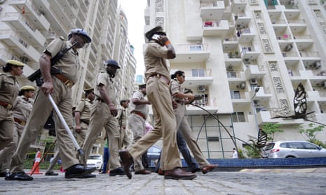 Policemen stand guard outside a housing society, Mahagun Moderne in Noida, India. 