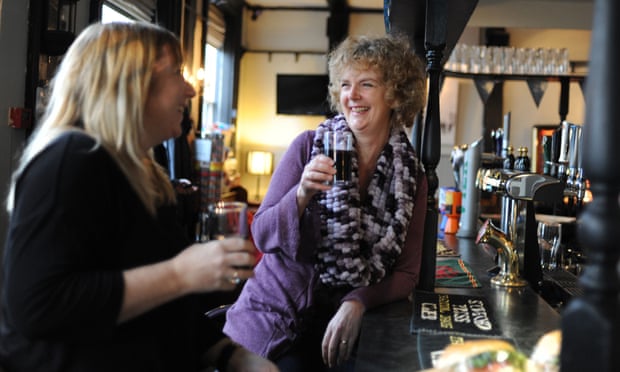 two women drink in a pub