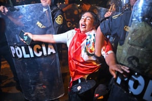 Lima, Peru. Police officers confront a protester during a demonstration against the government of President Dina Boluarte