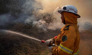A firefighter tackles a blaze at Canungra in Queensland