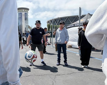 Bernardo Ramallo (left) playing soccer with students outside Oakland Coliseum
